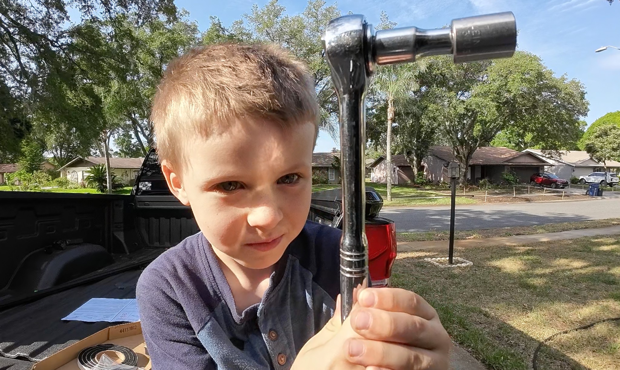 Founder's grandson holding a socket wrench, learning the tools of the trade.